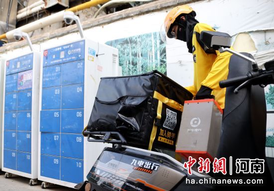 图为跑腿骑手在万洋锂电池快速换电站更换电池。王中举 摄 图为跑腿骑手在万洋锂电池快速换电站更换电池。王中举 摄