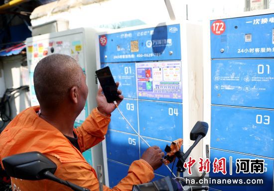 图为跑腿骑手在万洋锂电池快速换电站更换电池。王中举 摄 图为跑腿骑手在万洋锂电池快速换电站更换电池。王中举 摄