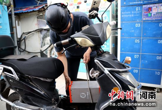 图为跑腿骑手在万洋锂电池快速换电站更换电池。王中举 摄 图为跑腿骑手在万洋锂电池快速换电站更换电池。王中举 摄