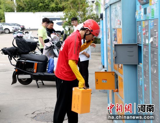 图为跑腿骑手在万洋锂电池快速换电站更换电池。王中举 摄 图为跑腿骑手在万洋锂电池快速换电站更换电池。王中举 摄