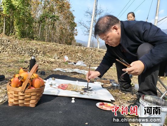 图为书画家在创作柿子主题书画作品。 图为书画家在创作柿子主题书画作品。