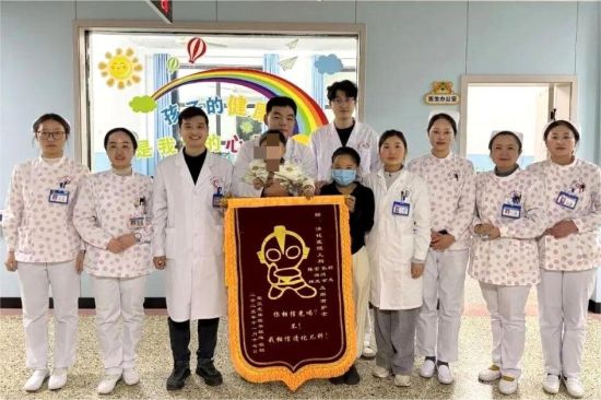 图为患儿家属将锦旗送给儿科团队。 图为患儿家属将锦旗送给儿科团队。