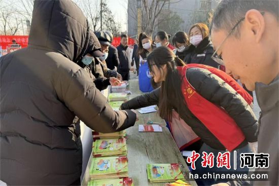 图为工作人员在发放宣传品。 图为工作人员在发放宣传品。