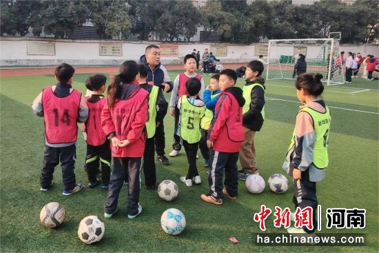 图为民进体育界会员为学生讲解足球技能。 图为民进体育界会员为学生讲解足球技能。