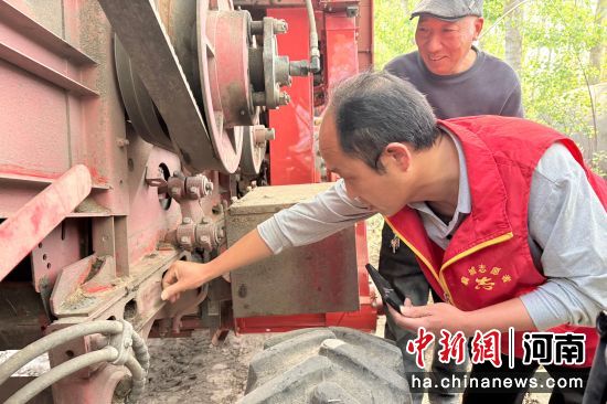 图为工作人员在向农机手讲解年检流程。 图为工作人员在向农机手讲解年检流程。