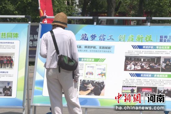 图为市民驻足观看职业教育活动周展板。 图为市民驻足观看职业教育活动周展板。