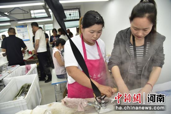 图为工人在熨烫布料。 图为工人在熨烫布料。