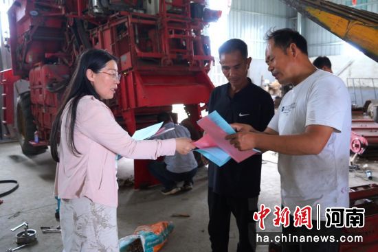 图为工作人员在给农机手讲解农技要点。 图为工作人员在给农机手讲解农技要点。