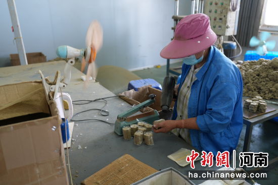 图为工人在对艾草制品进行封装作业。 图为工人在对艾草制品进行封装作业。