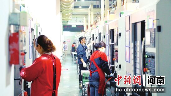 图为工人操作CNC机床加工智能零部件。 图为工人操作CNC机床加工智能零部件。