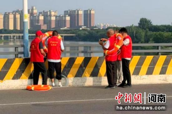 图为志愿者在汝河桥上投放救生圈。 图为志愿者在汝河桥上投放救生圈。