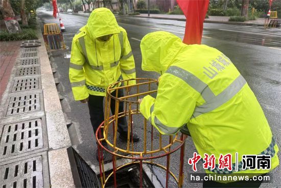 图为执法人员在布设排水口安全防护设施。张薇 摄 图为执法人员在布设排水口安全防护设施。张薇 摄