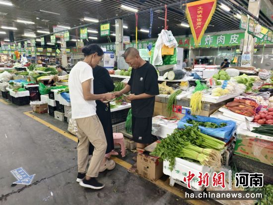 图为市民正在贾鲁智慧农贸市场购买蔬菜。 图为市民正在贾鲁智慧农贸市场购买蔬菜。