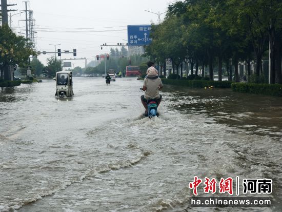 图为市民正在通过积水路段。 图为市民正在通过积水路段。