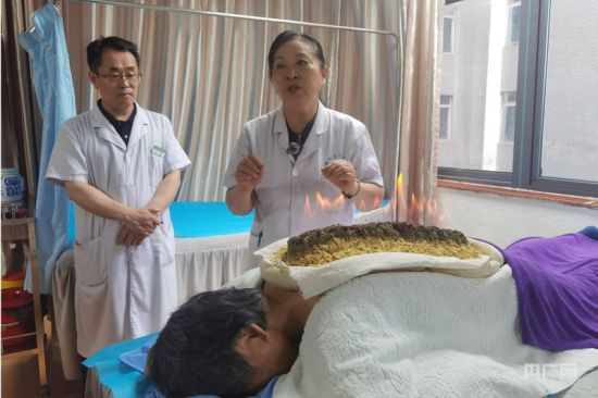 “王氏针灸学术流派”传承人王俊伏(中)为病人进行通督温阳长蛇灸(央广网记者 夏莎 摄) “王氏针灸学术流派”传承人王俊伏(中)为病人进行通督温阳长蛇灸(央广网记者 夏莎 摄)