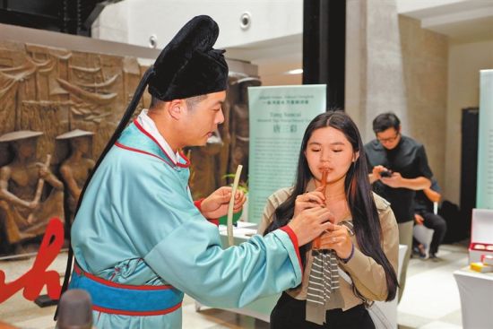 图② 当地市民体验吹奏贾湖骨笛。 图② 当地市民体验吹奏贾湖骨笛。