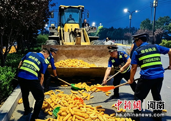 图为执法人员帮助群众清除影响通行的晾晒玉米。左振峰 摄 图为执法人员帮助群众清除影响通行的晾晒玉米。左振峰 摄