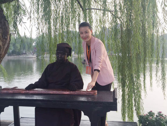 图为景区真人版雕塑做出抚琴的姿势,并陶醉在其中.王秋兰摄